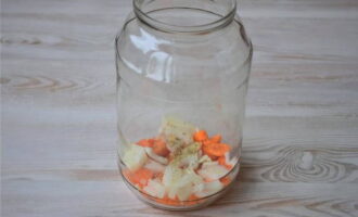 Place the prepared ingredients in a clean jar in layers. Place some of the onions and carrots in the first layer and sprinkle them with salt and fish seasoning.