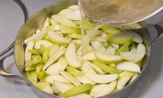 Giet het aangezuurde water uit de appelschijfjes en giet kokende siroop over de appels.