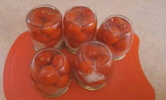 Seterusnya, letakkan tomato di dalam salji dengan bawang putih dalam balang liter pada penutup, tutupnya dengan kot pengetinan anda dan, selepas menyejukkan sepenuhnya, pindahkan ke penyimpanan di tempat yang sejuk dan gelap. Perapan yang mulanya keruh disebabkan oleh bawang putih akan menjadi jelas dari semasa ke semasa. Semoga berjaya dan penyediaan yang lazat!