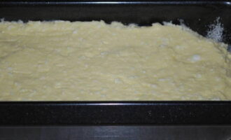 Heat the oven by setting the switch to 180 degrees. Carefully coat the bottom and sides of the baking dish with butter. Carefully transfer the curd dough and distribute evenly throughout the entire pan, lightly tapping it on the table.