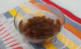 Place the raisins in a bowl and pour hot water over them for 15 minutes to swell.