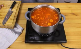 Fjern de kogte ribben fra bouillonen med en hulske, adskil kødet fra benene og skær det i små stykker. Læg alt det hakkede kød og de stegte grøntsager i den kogende bouillon og kog hodgepodgen ved svag varme i 5 minutter.