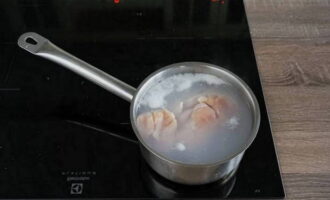 La ensalada con picatostes es fácil de preparar en casa. Enjuague la carne de pollo. Colocar en una cacerola, llenar con agua y colocar al fuego.Llevar a ebullición, quitar la espuma que se forme. Cocine hasta que esté cocido, verifique con un tenedor.