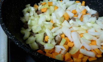 Remove the skin from the onion, rinse and chop with a sharp knife. Cut the sweet pepper into cubes, after washing and removing the insides. Peel the carrots with a vegetable peeler and cut into cubes. Add the vegetables to the meat and cook for 20 minutes, remembering to turn over.