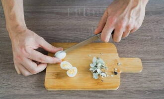 Enjuague los huevos de codorniz y cocínelos previamente en agua con sal. Dejar enfriar los huevos y pelarlos una vez que se hayan enfriado. Cortar por la mitad a lo largo.