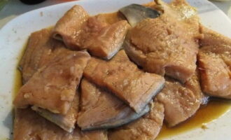 Potong fillet salmon merah jambu yang telah diperap ke dalam kepingan saiz yang dikehendaki.