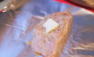 Spread baking foil on a baking sheet, place a piece of turkey meat, and place a piece of butter on top. Butter will give the meat tenderness and juiciness.