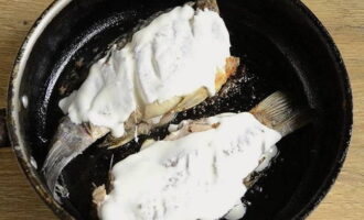 When the fish is golden brown on both sides, spread sour cream on top. Fry with a lid. Then carefully turn it over and do the same procedures on the other side.