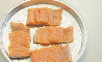 Place pieces of pink salmon into a disposable baking dish and add salt.