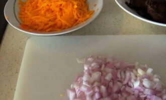 While the liver is frying, peel the onions and carrots. Cut the onion into cubes and chop the carrots on a coarse grater.