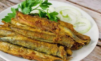 Place the fried capelin on a plate.