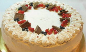 Decorate the cake with cream, berries and chocolate pieces.