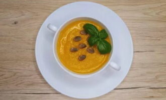 Versez la soupe à la citrouille brillante dans des bols. Décorez avec votre verdure préférée et saupoudrez de graines de citrouille. Appelez votre famille et servez une délicieuse gâterie ! Apprécier!