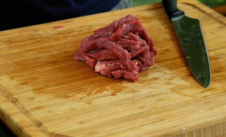 Tagliare la carne preparata a strisce sottili.