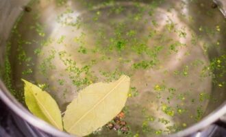 Pour 2 liters of water into a saucepan. Add bay leaf, black peppercorns, ground pepper and persilade seasoning (a mixture of chopped parsley and garlic). Season with salt and pepper. Heat until hot.