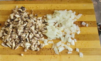 Prendi la cipolla e rimuovi lo strato superiore. Tritare finemente. Togliere la pelle alle cappelle degli champignon, rinnovare il taglio sul gambo e tagliare i funghi a cubetti.