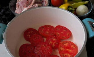 Ta en beholder med tykke vegger og en tung bunn. Skyll de kjøttfulle tomatene, tørk dem og skjær dem i ganske tykke skiver. For bunnen av beholderen med dem.