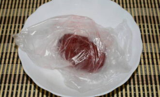 We fill the bag with some air and tie it in a knot. Place the vegetable in the bag on a microwave-safe plate.