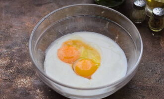 Tuangkan kefir ke dalam mangkuk yang dalam. Pecahkan telur ayam di sini dan masukkan garam.