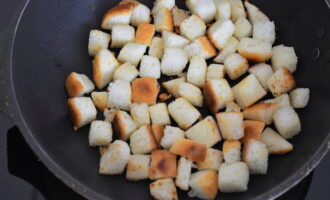 Aqueça uma frigideira com óleo vegetal. Frite o alho picado e depois o pão junto. Cozinhe até dourar.