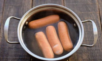 Boil sausages in boiling water for two to five minutes. The optimal cooking time is three minutes.