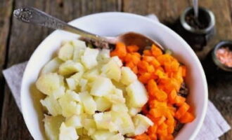 Togliere le patate e le carote bollite dalla buccia e tagliarle a cubetti. Aggiungi all'insalatiera.