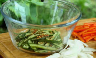 Durante la salatura i cetrioli rilasciavano del liquido.Ha bisogno di essere drenato. Integriamo le verdure stesse con zucchero, aglio tritato, scaglie di peperoncino e coriandolo.