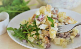 Uma salada brilhante com feijão enlatado e croutons está pronta. Sirva à mesa, guarnecido com verduras!