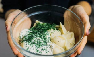 Using a slotted spoon, place dumplings in a bowl. Season with sour cream. Sprinkle with chopped herbs. Treat your loved ones. Bon appetit!