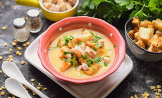 Despeje o purê de sopa de ervilha preparado de acordo com a receita clássica em tigelas e coloque os croutons e o bacon frito em cada tigela, decore com ervas e sirva o prato. Bom apetite!