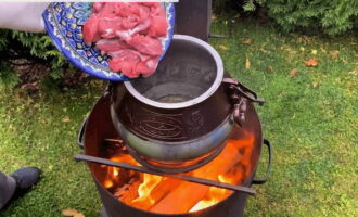 Place the Afghan cauldron over an open fire/bonfire and heat the vegetable oil in it. Then fry the lamb pieces well in oil until golden brown on all sides. Fry the meat for at least 10 minutes.