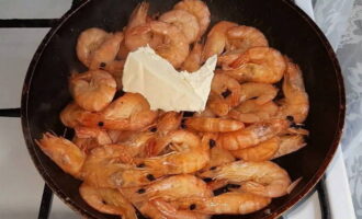 After the water has evaporated, add a piece of butter to the shrimp and fry them over medium heat, stirring constantly with a spatula for 2 minutes.