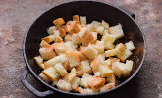 Corte as fatias de pão em cubos, despeje o óleo vegetal, polvilhe com os temperos e leve ao forno pré-aquecido por 15 minutos.