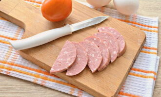 Que cuisiner pour un petit-déjeuner rapide et savoureux ? Préparons les produits nécessaires. Coupez le saucisson en fins demi-cercles.