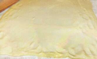 Defrost the package of puff pastry dough. Roll out one layer and place it on a baking sheet.