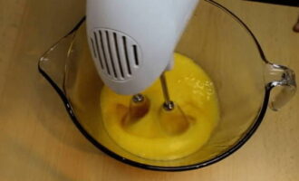 Break the eggs into a separate bowl, add sugar and beat them with a mixer at high speed until the volume doubles.