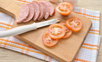 We wash the tomato and carefully cut out the stem. Cut the vegetable itself into thin circles.