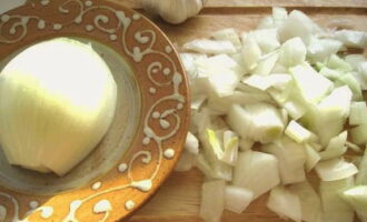 We peel a large onion and cut it in half, cut one part into arbitrary cubes and add it to the beans at the beginning of cooking.