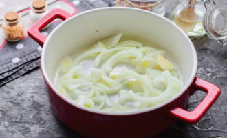 Chop the onion heads into half rings. Transfer some of it to the container in which you are going to bake the dish.