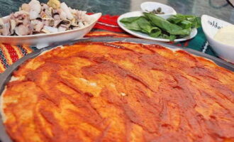 Coat the pizza base with tomato sauce.