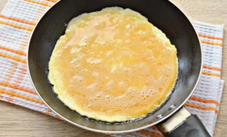 Heat a frying pan with vegetable oil. Pour in the egg mixture here. Distribute it over the entire surface of the pan.