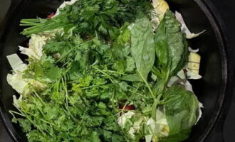 Remove wilted leaves from cabbage. Remove whole good leaves and set aside. Coarsely chop the remaining cabbage and add salt and cumin. Place in a cauldron. Cover the top with bunches of greenery. Seal with whole cabbage leaves. Place a weight - a flat plate. Close the lid tightly.