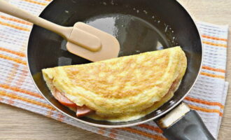 Apabila telur telah ditetapkan, berhati-hati menutup inti dengan separuh pancake telur.