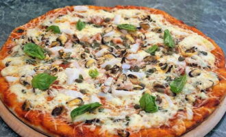 Appetizing pizza with seafood at home is ready. Slice and serve!