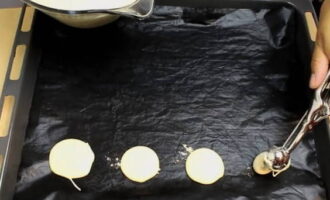 Cover the baking sheet with paper.Using a large spoon, place the kneaded dough onto a baking sheet in the form of identical round cakes and at a distance from each other.