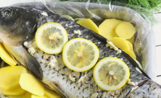 Coupez le citron en tranches, remplissez la carcasse de tranches de citron et déposez-en quelques-unes sur le poisson.