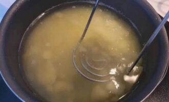 Mash the boiled potatoes with a masher and add to the broth.