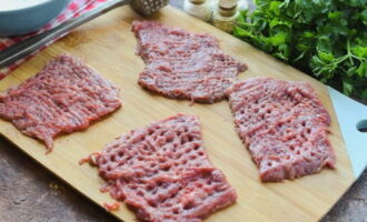 Corte a carne em porções, cubra com filme e bata com um martelo dos dois lados.