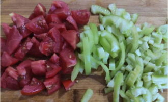 Snijd de tomaten grof en snijd het vruchtvlees van de paprika in repen.