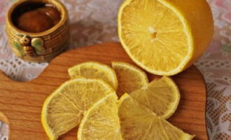 Rinse and dry the lemon. Cut the citrus into thin slices.